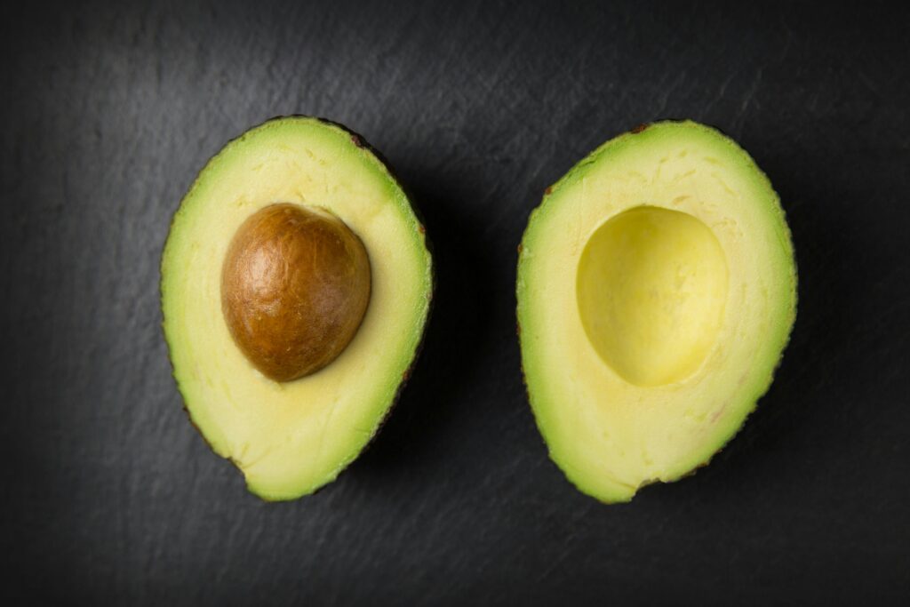 Halved avocado on black background
