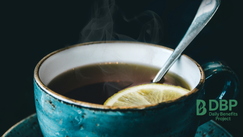 Warm Lemon Water in a Steaming Mug A cup of steaming warm lemon water with a slice of lemon and spoon