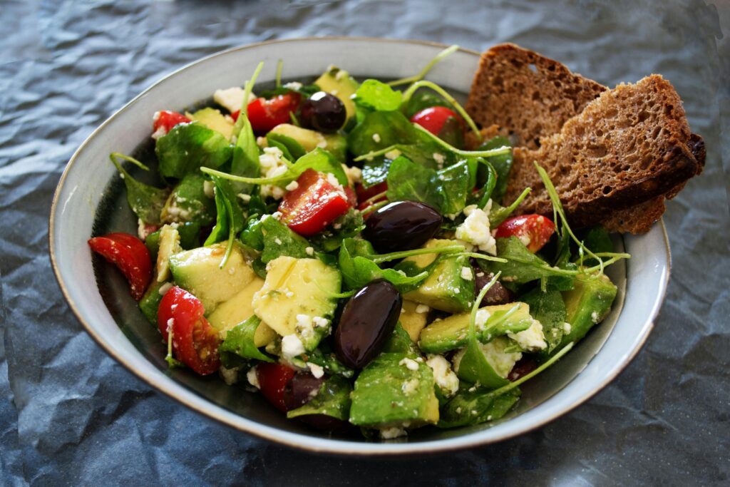 Fresh avocado salad with olives and tomatoes