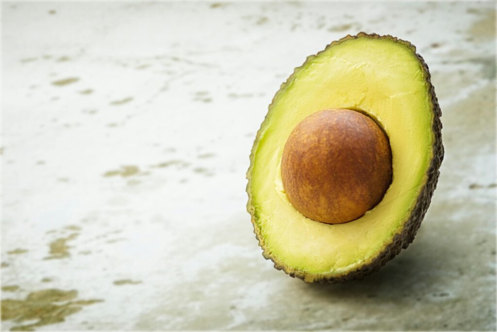 Fresh avocado half on white table