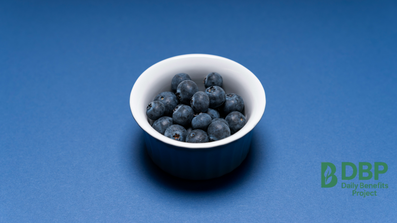 Minimal Blueberry Bowl A small white bowl of blueberries on a blue background