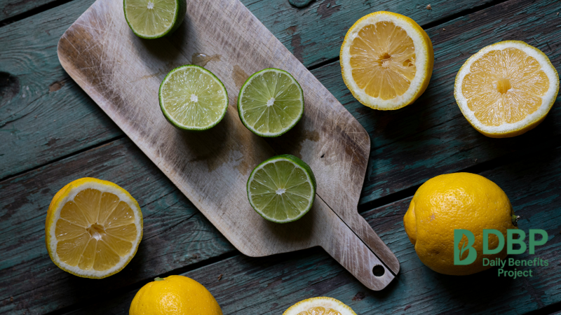 Lemons and limes halved on a wooden board for side-by-side comparison
