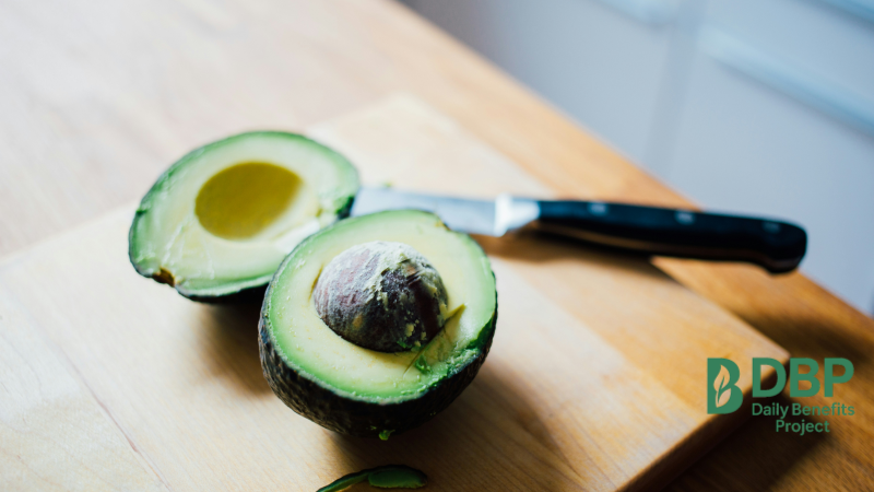 Fresh Avocado on Cutting Board Halved avocado with a knife on a wooden cutting board